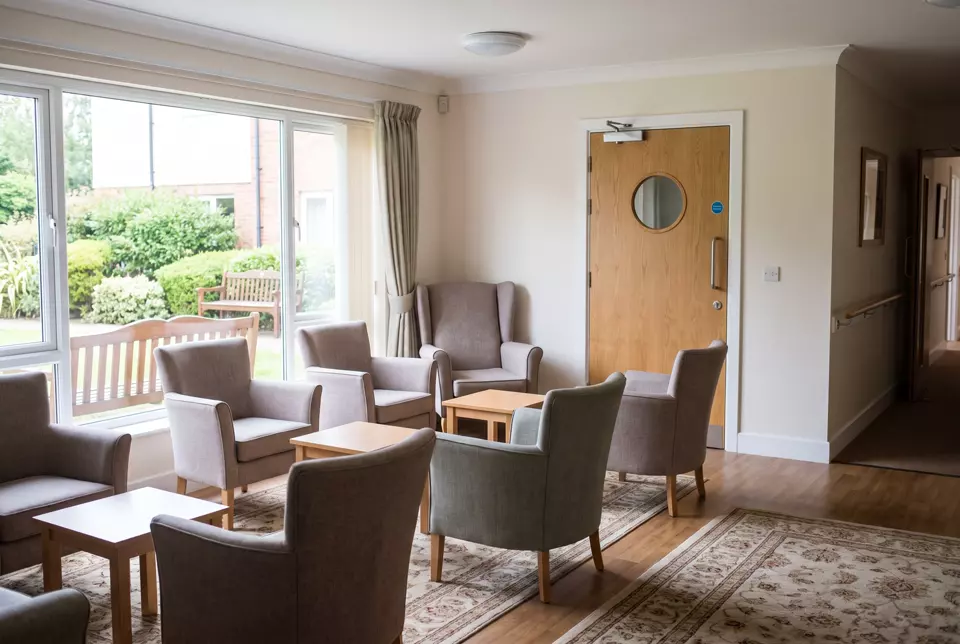 A care home lounge with a glazed fire door